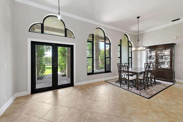 unfurnished dining area featuring a chandelier, light tile patterned flooring, french doors, and crown molding