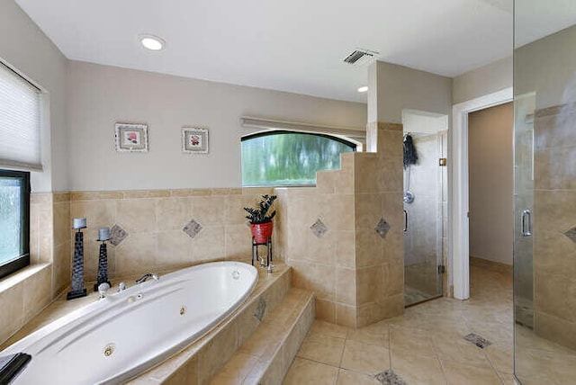 bathroom with tile walls, tile patterned floors, and separate shower and tub