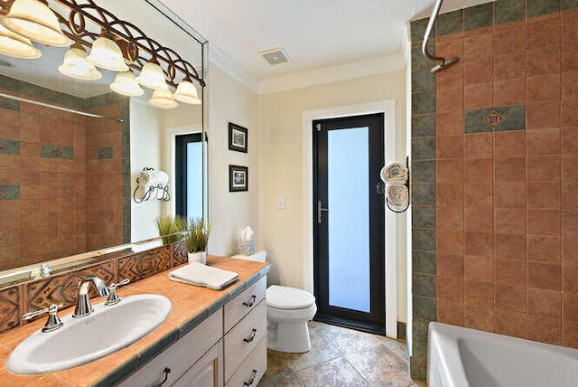 full bathroom with vanity, tile patterned flooring, ornamental molding, toilet, and tiled shower / bath