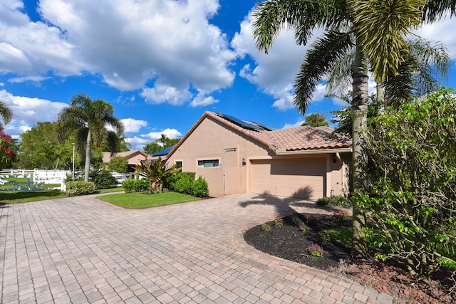 view of home's exterior featuring a garage and solar panels