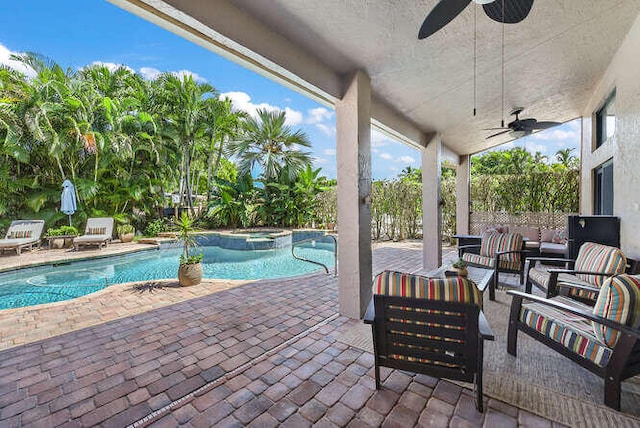 view of pool with an in ground hot tub, outdoor lounge area, ceiling fan, and a patio area