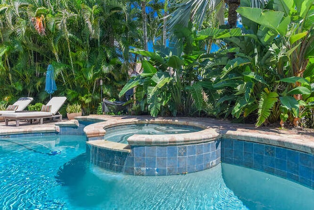 view of swimming pool featuring an in ground hot tub