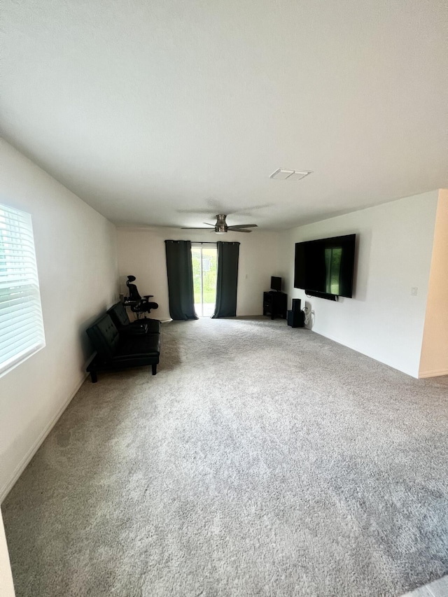 unfurnished living room featuring visible vents, carpet flooring, and a ceiling fan