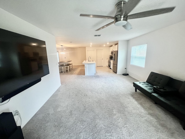 living area featuring a ceiling fan, light colored carpet, and visible vents