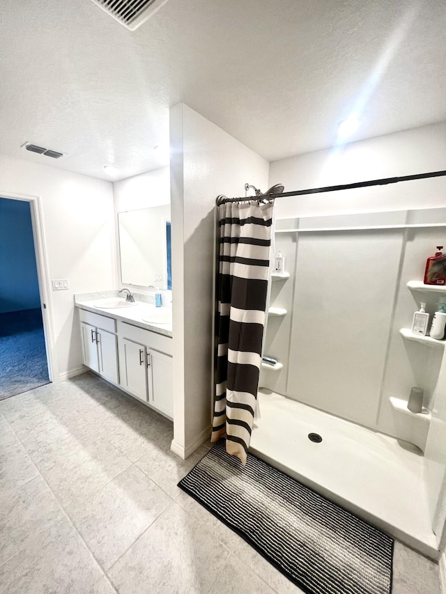 full bath featuring a textured ceiling, visible vents, curtained shower, and vanity