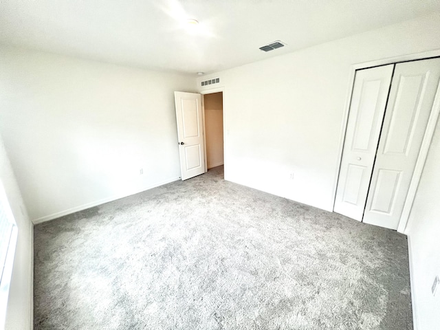 unfurnished bedroom with a closet and carpet flooring