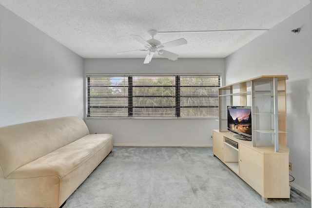 carpeted living room featuring a textured ceiling and ceiling fan