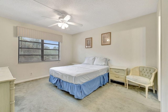 bedroom with a textured ceiling, light carpet, and ceiling fan