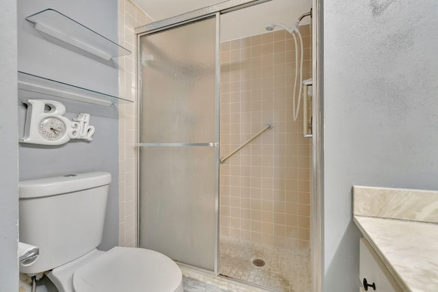 bathroom with toilet, vanity, and a shower with shower door