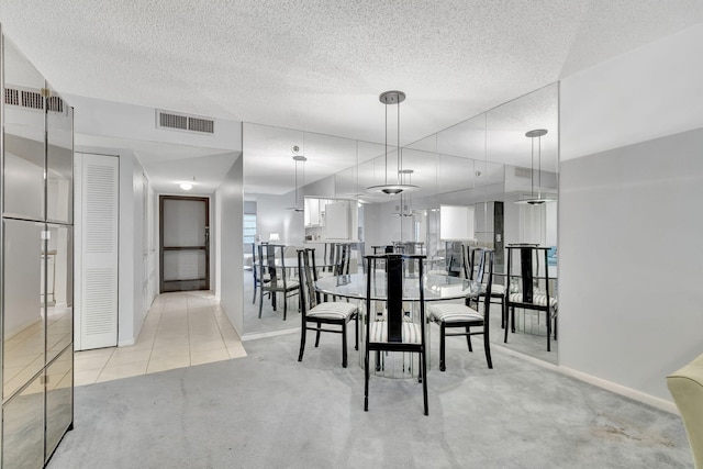 carpeted dining area featuring a textured ceiling