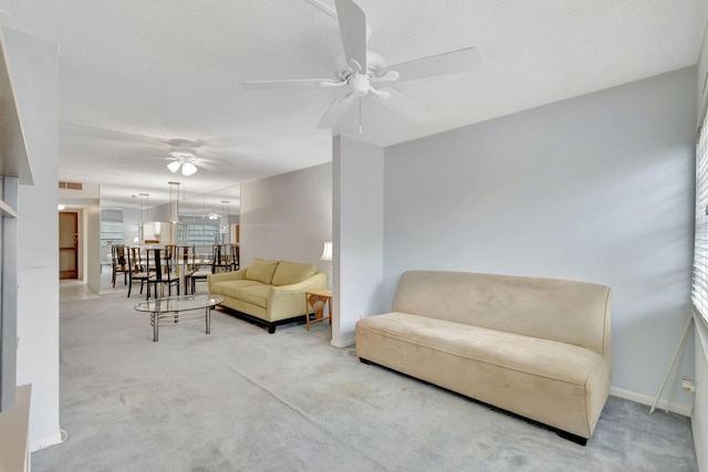 carpeted living room featuring ceiling fan with notable chandelier and a textured ceiling