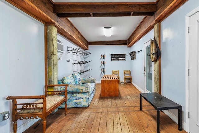 mudroom with beamed ceiling, a wall unit AC, and wood-type flooring