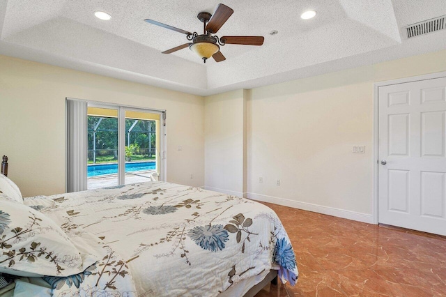 bedroom with a textured ceiling, a raised ceiling, access to exterior, and ceiling fan