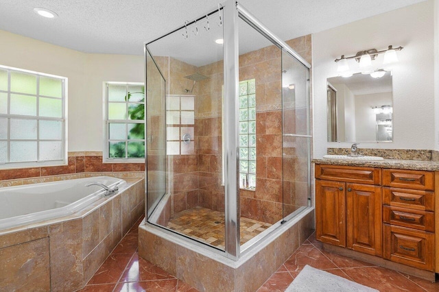 bathroom with vanity, tile patterned floors, a textured ceiling, and plus walk in shower