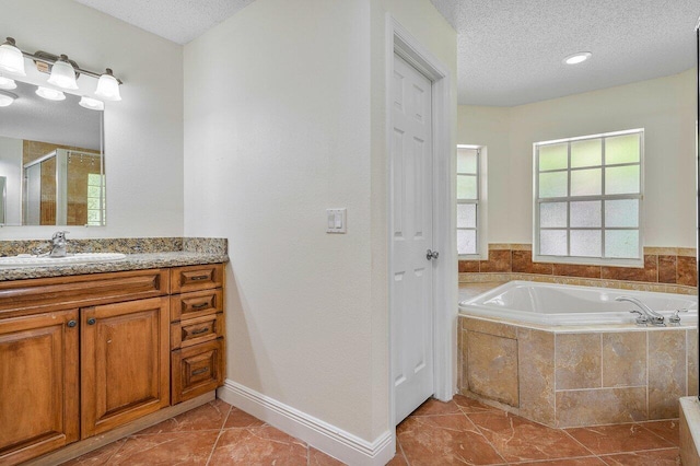 bathroom with vanity, a textured ceiling, and separate shower and tub