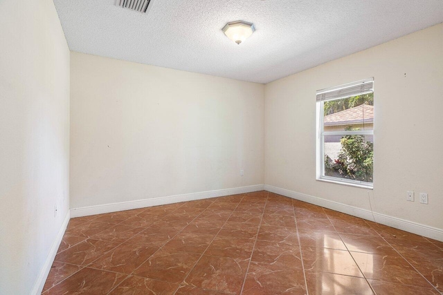 unfurnished room featuring a textured ceiling