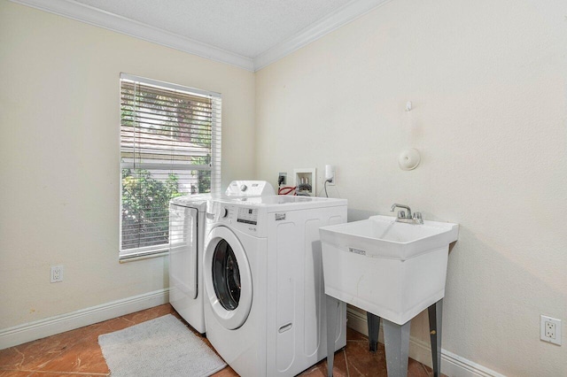 washroom featuring washer and dryer, ornamental molding, and a textured ceiling