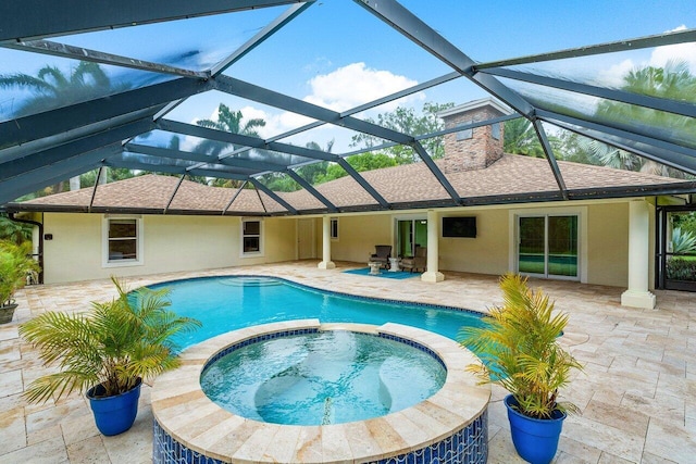 view of pool featuring a patio area, an in ground hot tub, and glass enclosure