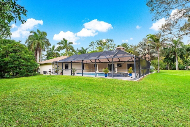 rear view of property with a patio area, a lanai, and a yard