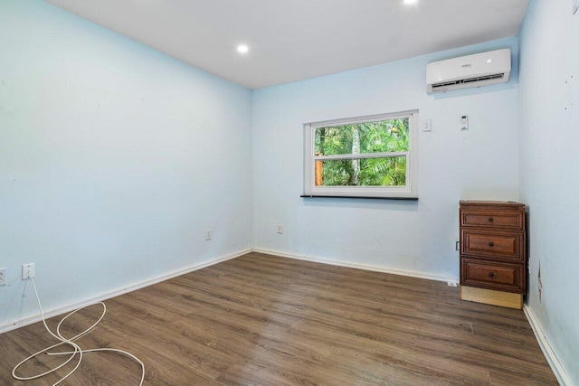 unfurnished room featuring dark hardwood / wood-style floors and a wall unit AC