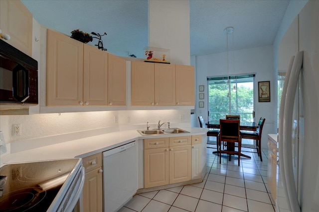 kitchen with white appliances, light tile patterned flooring, sink, and pendant lighting