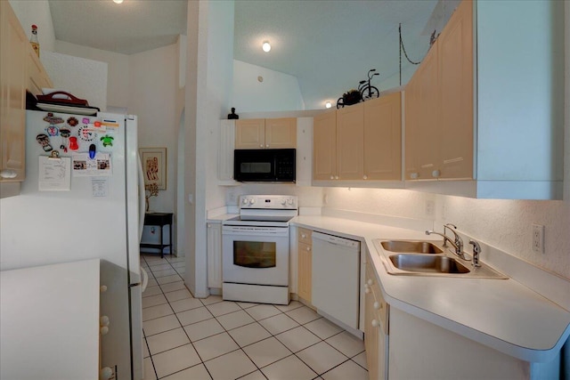 kitchen featuring white appliances, vaulted ceiling, sink, and light tile patterned floors