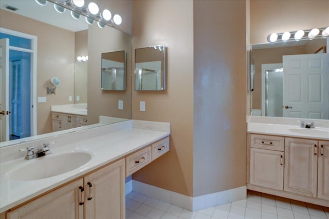 bathroom with tile patterned flooring, walk in shower, and vanity