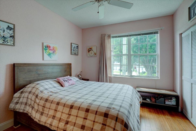 bedroom featuring a closet, ceiling fan, hardwood / wood-style flooring, and a textured ceiling