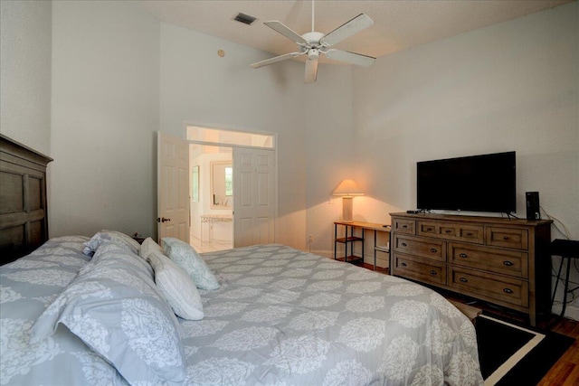 bedroom with ceiling fan, ensuite bathroom, and dark wood-type flooring