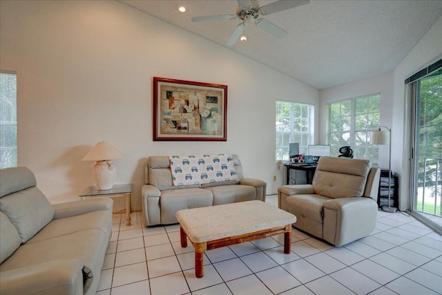 tiled living room with ceiling fan, a textured ceiling, plenty of natural light, and vaulted ceiling