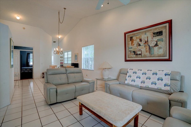 living room featuring ceiling fan with notable chandelier, light tile patterned floors, and high vaulted ceiling