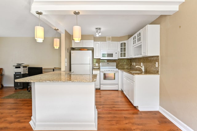 kitchen featuring hanging light fixtures, white appliances, white cabinetry, and hardwood / wood-style floors