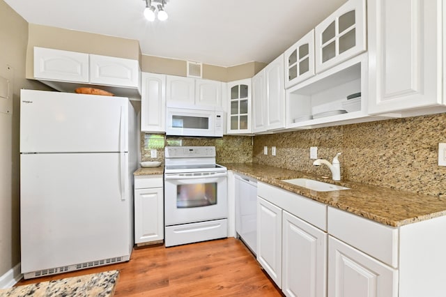 kitchen with light wood-type flooring, sink, white appliances, white cabinetry, and light stone countertops