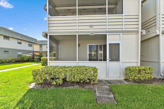 exterior space with a balcony and a lawn