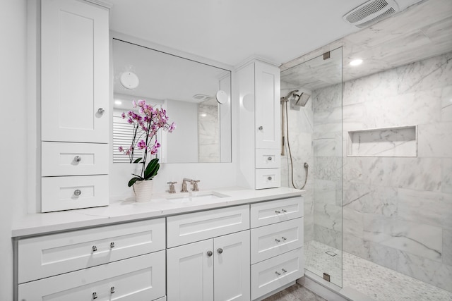 bathroom featuring vanity and tiled shower