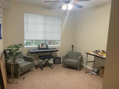 living area featuring ceiling fan and light colored carpet