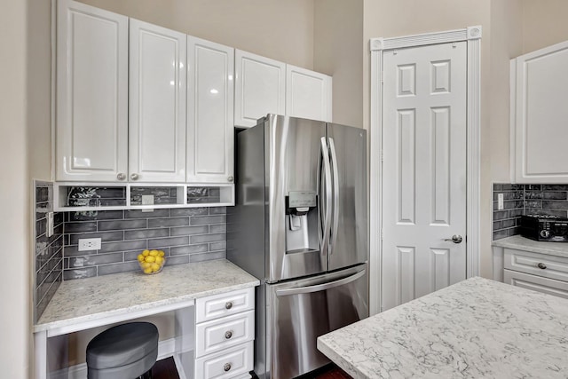 kitchen featuring backsplash, stainless steel fridge with ice dispenser, and white cabinets