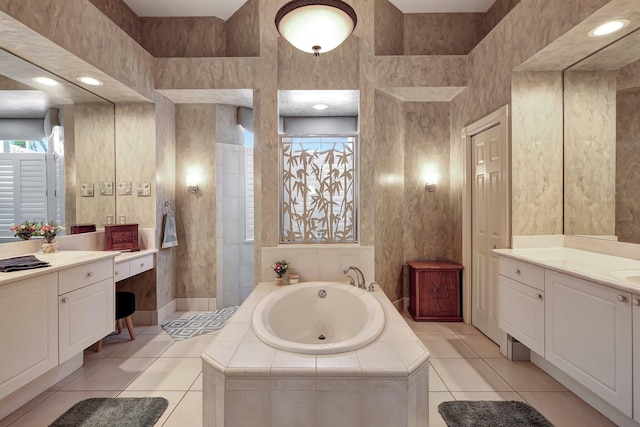 bathroom with vanity, tile patterned flooring, and tiled bath