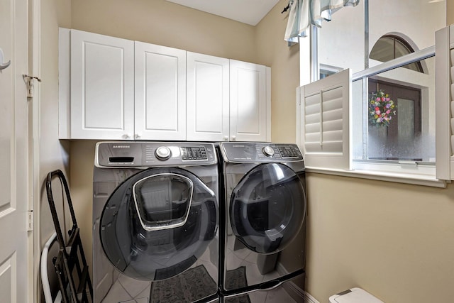 washroom with tile patterned floors, independent washer and dryer, and cabinets