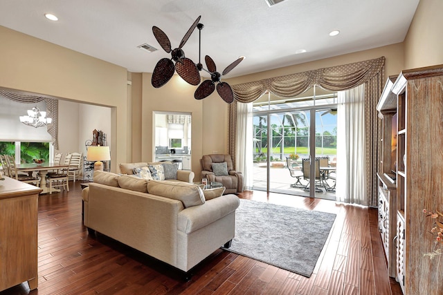 living room with dark wood-type flooring and ceiling fan with notable chandelier