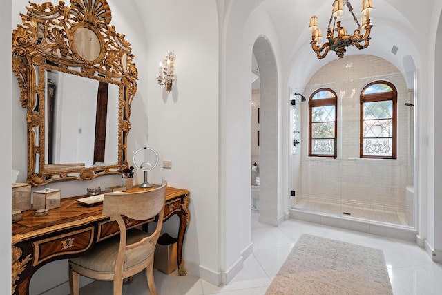 bathroom with tile patterned flooring, vanity, walk in shower, and a notable chandelier