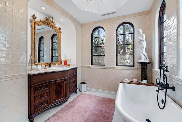 bathroom with vanity, tile walls, and a tub