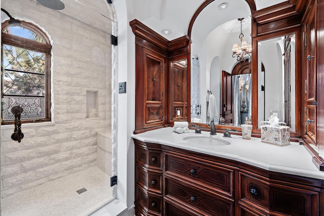 bathroom featuring vanity, a tile shower, tile walls, and a chandelier