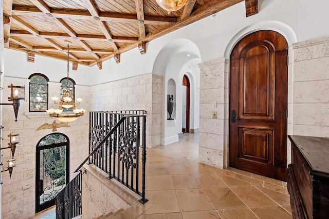 hall featuring beam ceiling, wooden ceiling, a healthy amount of sunlight, and tile walls