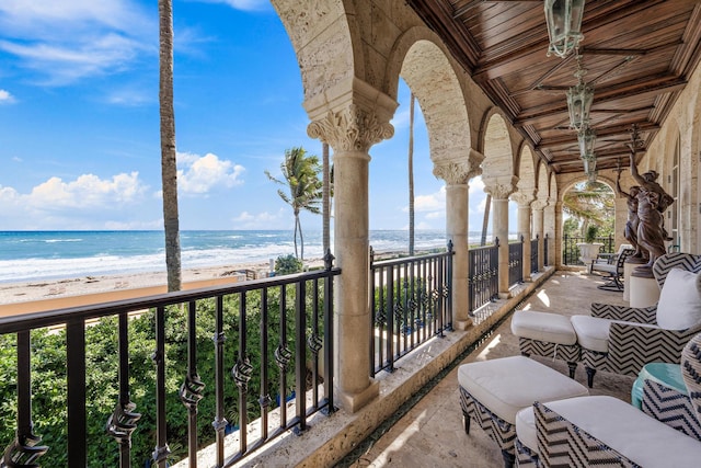 balcony featuring a view of the beach and a water view