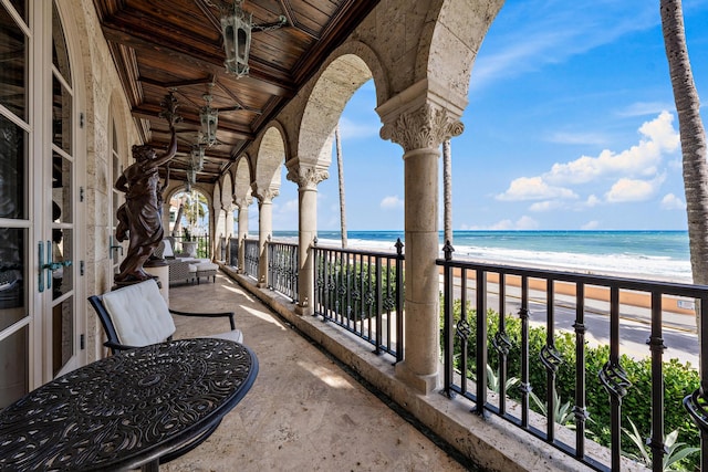 balcony featuring a water view and a view of the beach