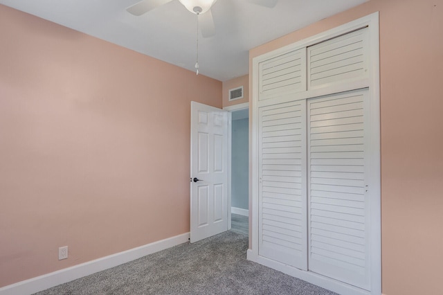 unfurnished bedroom featuring carpet, ceiling fan, and a closet