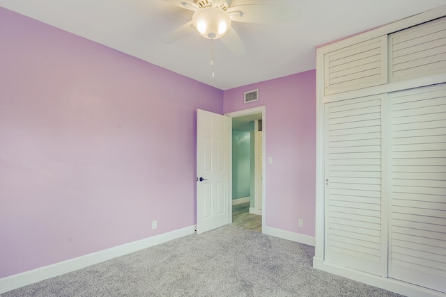 unfurnished bedroom featuring light carpet, ceiling fan, and a closet