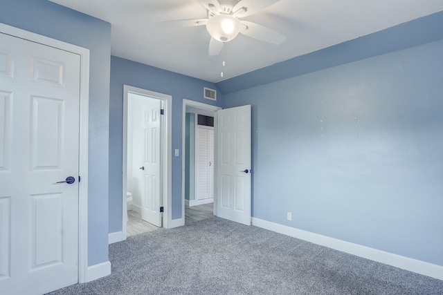 unfurnished bedroom featuring ceiling fan, ensuite bath, and light carpet