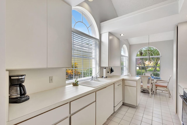 kitchen with dishwasher, white cabinetry, sink, and vaulted ceiling